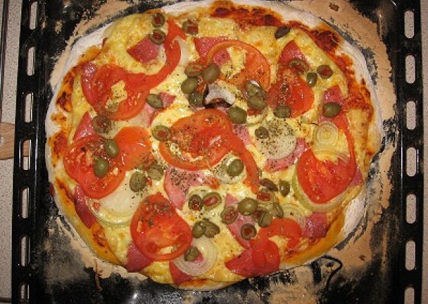 Fotografia przedstawiająca Pizza z oliwkami i pomidorami i salami