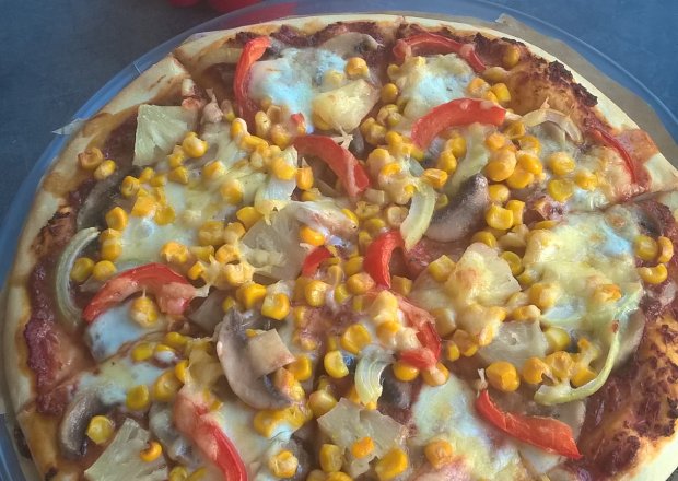 Fotografia przedstawiająca Pizza z pieczarkami, ananasem, kukurydzą i papryką