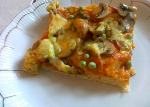 Fotografia przedstawiająca pizza z pieczarkami i zielonym groszkiem