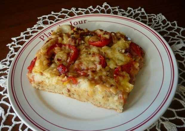 Fotografia przedstawiająca pizza z pomidorami i cebul
