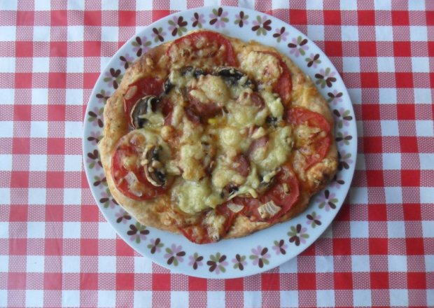 Fotografia przedstawiająca Pizza z pomidorami i kiełbasą