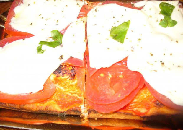 Fotografia przedstawiająca Pizza z pomidorami i mozarellą