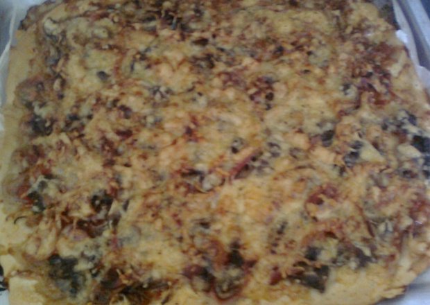 Fotografia przedstawiająca Pizza z pomidorami, szynką, pieczarkami i serem