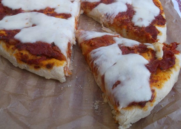 Fotografia przedstawiająca Pizza z pomidorowym sosem i mozzarellą.