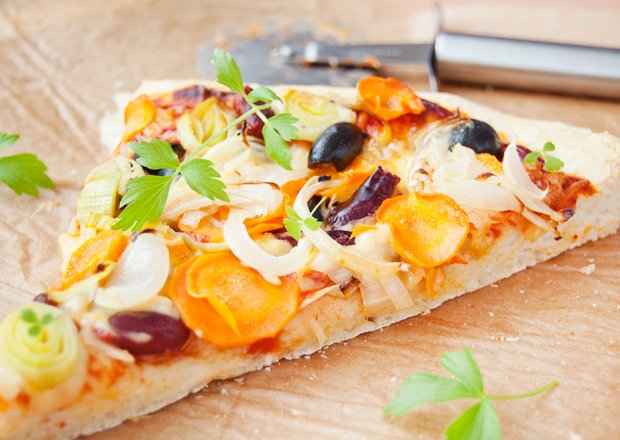 Fotografia przedstawiająca Pizza z porem, marchewką, oliwkami i fasolą