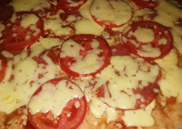 Fotografia przedstawiająca Pizza z salami, pomidorem i serem