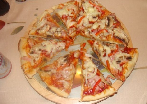 Fotografia przedstawiająca pizza z serowym ciastem i dodatkami