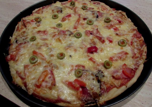 Fotografia przedstawiająca Pizza z szynką i oliwkami