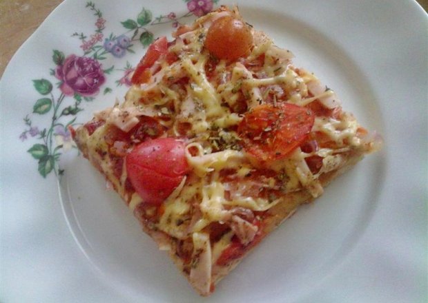 Fotografia przedstawiająca Pizza z szynką i pomidorkami