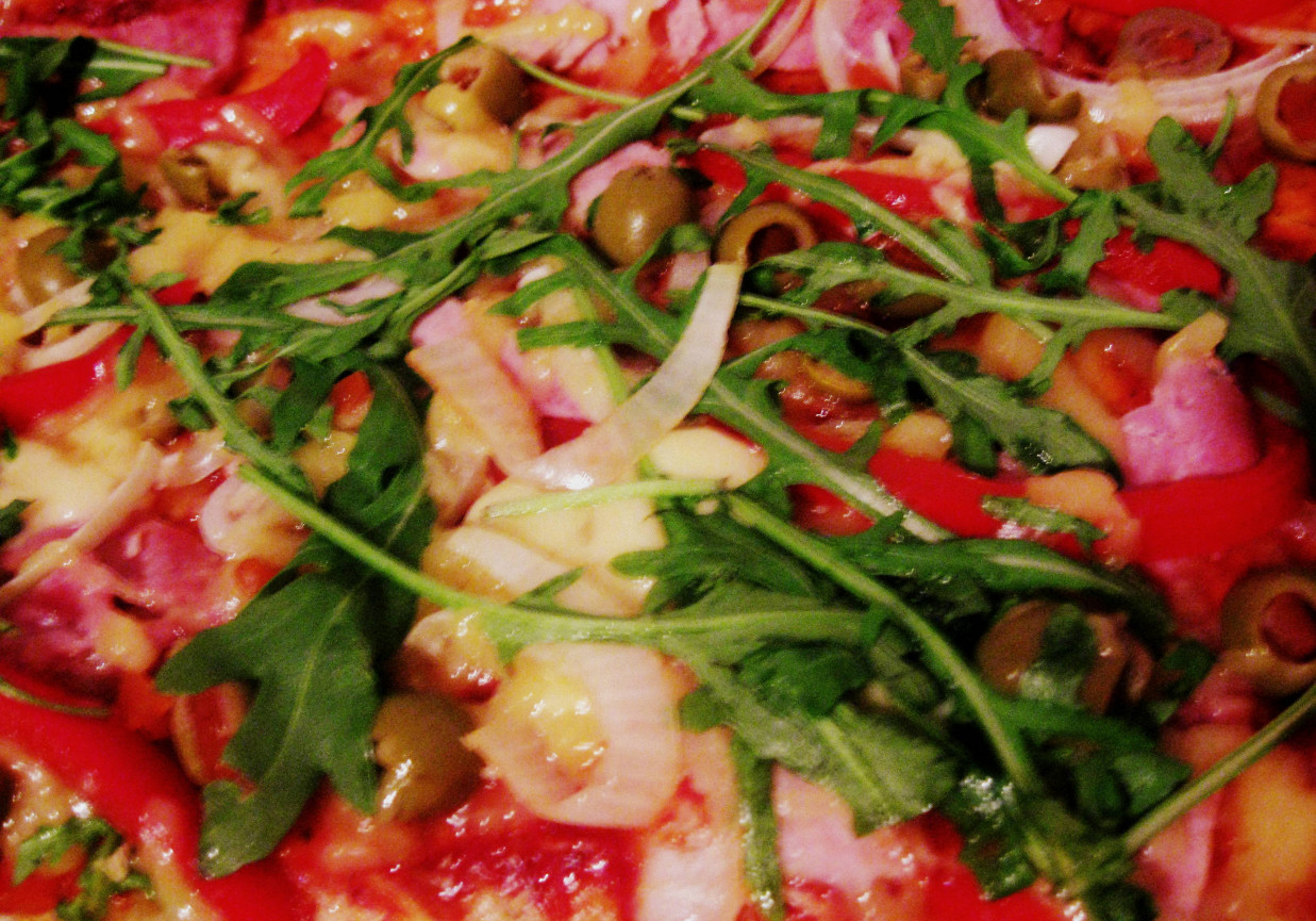 Pizza z szynką, oliwkami, papryką i rukolą foto