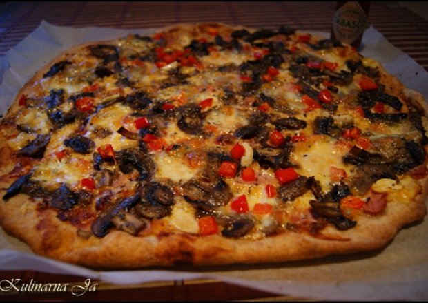 Fotografia przedstawiająca Pizza z szynką, pieczarkami i papryką