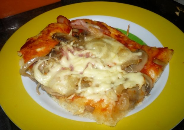 Fotografia przedstawiająca Pizza z szynką, pieczarkami i serem mozarella