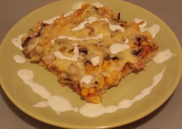 Fotografia przedstawiająca Pizza z szynką, pieczarkami, kukurydzą i serem