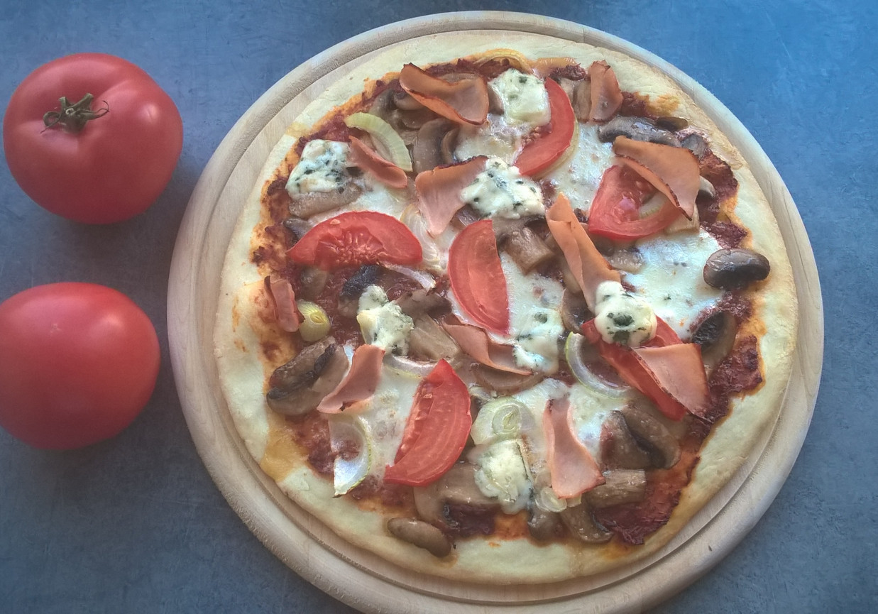 Pizza z szynką, serem, pomidorem i pieczarkami foto