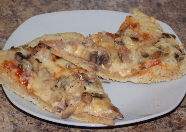 Fotografia przedstawiająca Pizza z tuńczykiem, szynką i pieczarkami