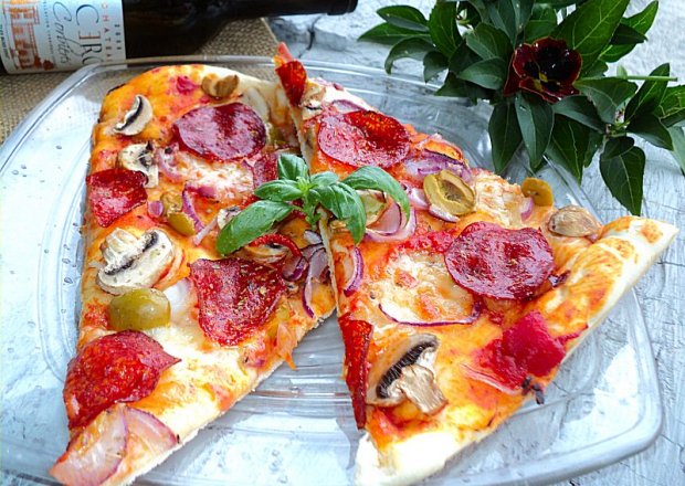 Fotografia przedstawiająca Pizza z wędzonym serem, oliwkami, salami, sosem pomidorowym