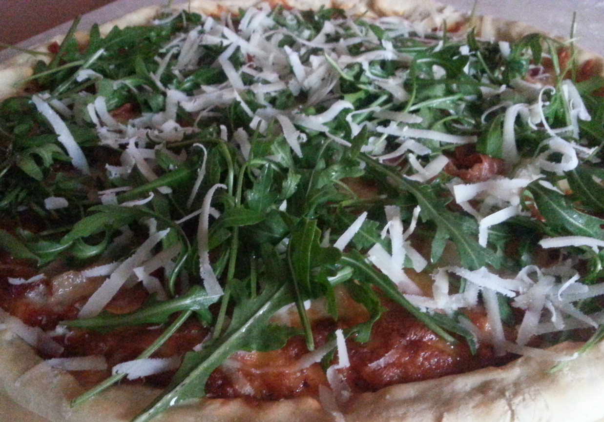 Pizza z włoską szynką sezonową, boczkiem, rukolą i parmezanem foto