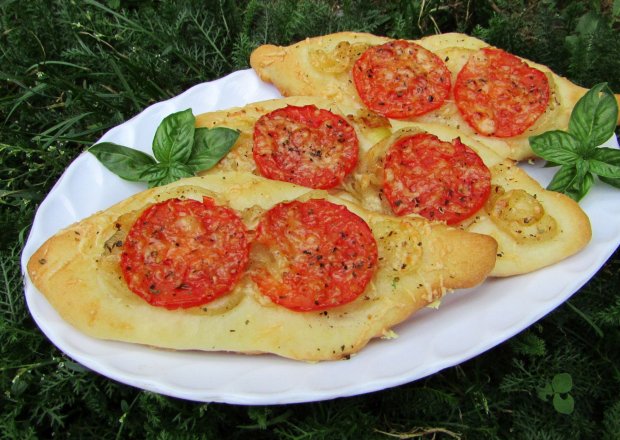 Fotografia przedstawiająca Pizzeriny łódki z pomidorami i bazylią