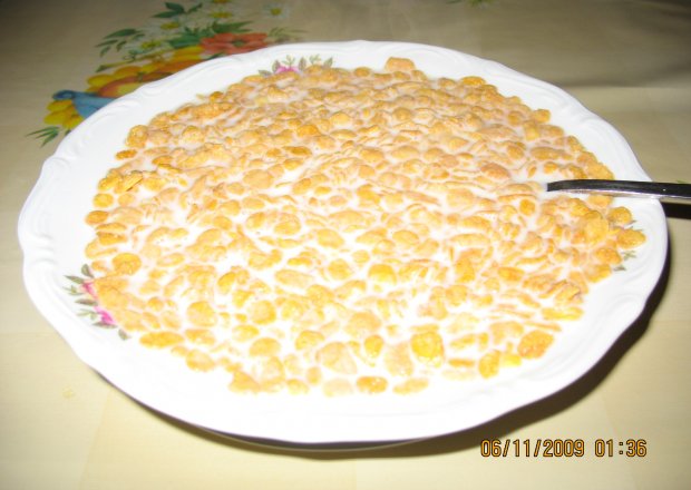 Fotografia przedstawiająca płatki kukurydziane na mleku