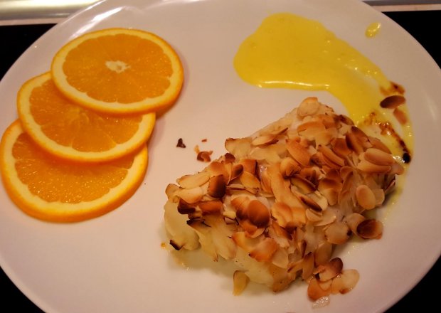 Fotografia przedstawiająca Polędwica z dorsza z prażonymi migdałami z sosem pomarańczowym