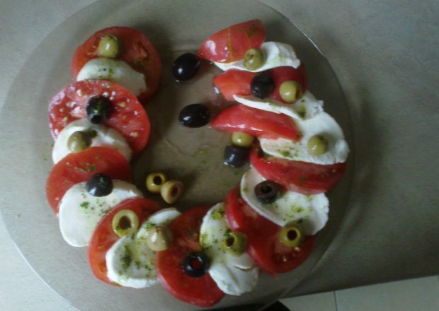 Fotografia przedstawiająca pomidory z mozarellą i oliwkami