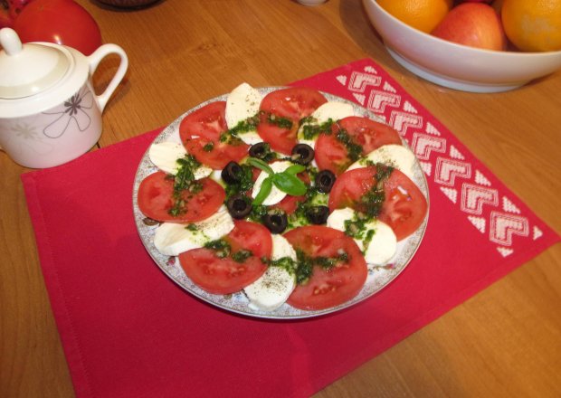 Fotografia przedstawiająca pomidory z pesto i mozzarellą