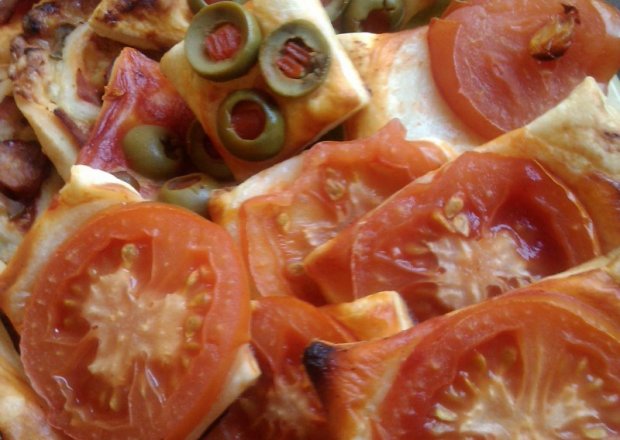 Fotografia przedstawiająca Przekąski na francuskim cieście z pomidorami lub oliwkami