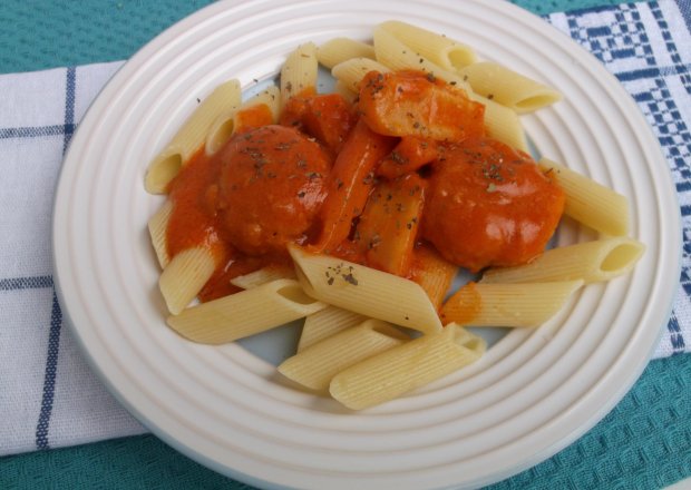 Fotografia przedstawiająca Pulpeciki drobiowe w sosie pomidorowym z warzywami.