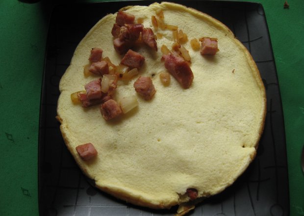Fotografia przedstawiająca puszysty omlet z szynką i cebulką
