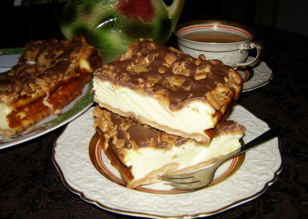 Fotografia przedstawiająca pyszny pieczony sernik z herbatnikami i polewą czekoladową...