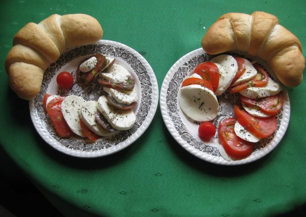 Fotografia przedstawiająca rogal z pomidorami i mozzarelą