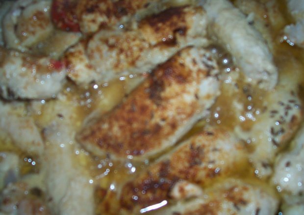 Fotografia przedstawiająca Roladki z kurczaka z suszonymi pomidorami owinięte boczkiem na sałacie lodowej.