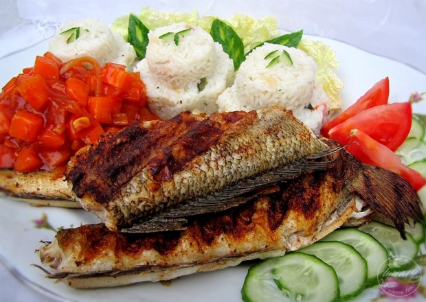 Fotografia przedstawiająca Ryba z grilla z ryżem i marchewką.