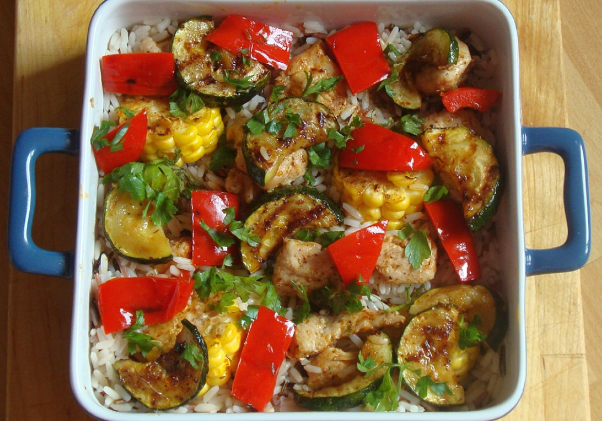 Ryż tricolore z grillowanym kurczakiem i warzywami posypany posiekaną natką pietruszki foto