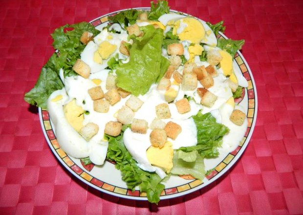 Fotografia przedstawiająca Sałata z jajkiem i grzankami w sosie jogurtowo-czosnkowym.