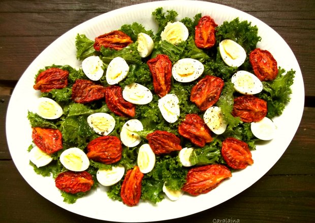 Fotografia przedstawiająca sałatka z jarmużem, suszonymi pomidorami i jajkami przepiórczymi