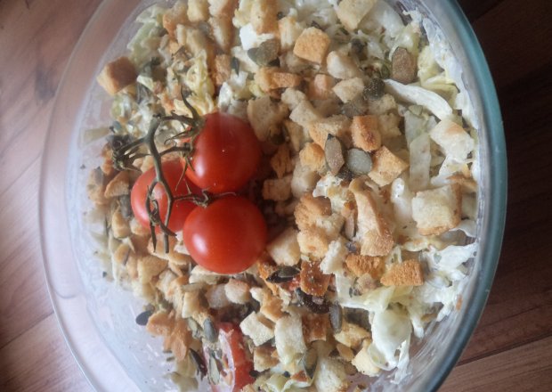 Fotografia przedstawiająca Sałatka z lodowej i grzanek- z dodatkiem jajka ,  cebulek, pomidorków i pestek dyni :)
