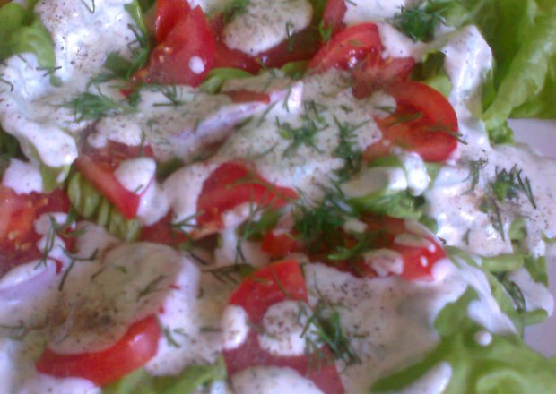 Fotografia przedstawiająca sałatka z sałaty i pomidorów z sosem kefirowo-ziołowym