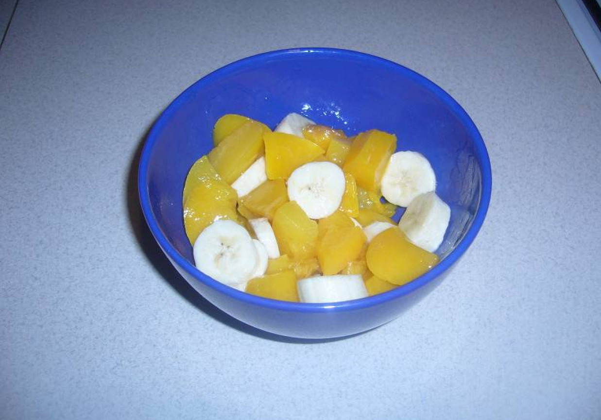 Słodka miseczka z brzoskwinią, bananem i jogurtem greckim posypana crunchami. foto
