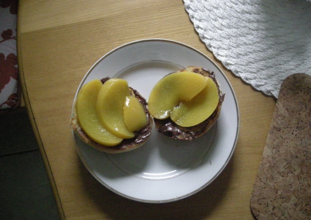 Fotografia przedstawiająca słodkie śniadanko- bułeczki na ciepło z czekoladą i brzoskwiniami