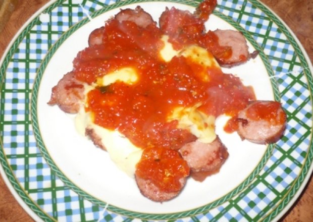 Fotografia przedstawiająca smażona kiełbasa z sosem i serem