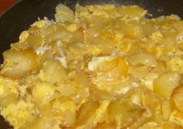 Fotografia przedstawiająca Smażone ziemniaki w plastrach zalewane jajkami