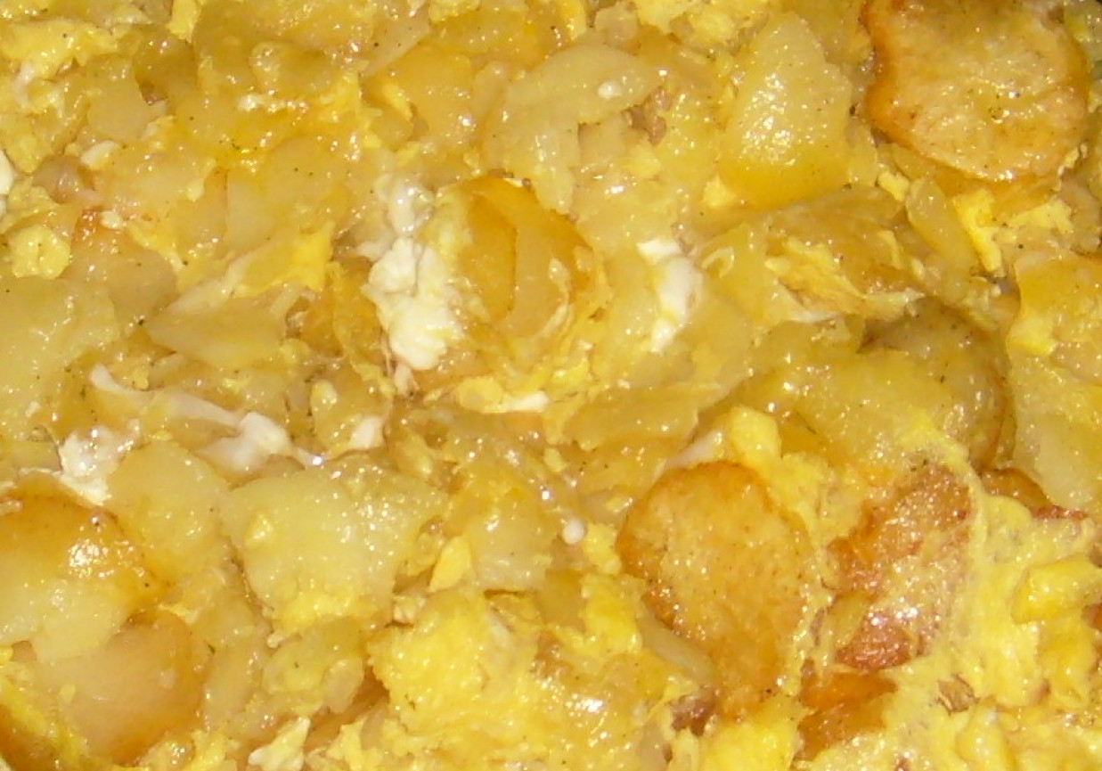 Smażone ziemniaki w plastrach zalewane jajkami foto