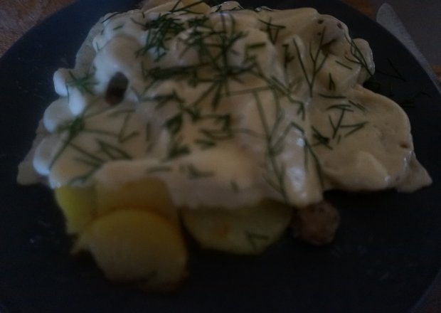 Fotografia przedstawiająca Smażone ziemniaki z białą kiełbasą pod kołderką z sera