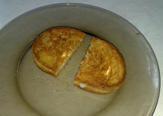 Fotografia przedstawiająca smazony chleb z serkiem topionym i cebula