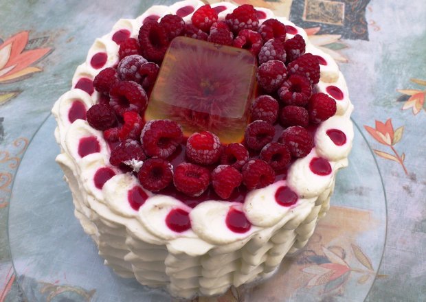 Fotografia przedstawiająca Śmietanowy tort z musem malinowym w pionowe pasy.