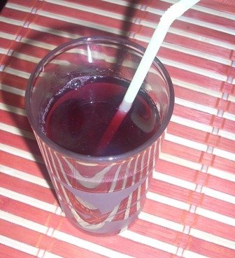 Fotografia przedstawiająca sok z aronii z dodatkiem liści malin