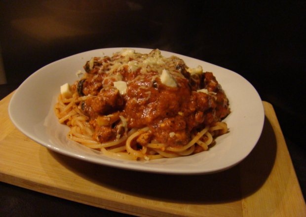 Fotografia przedstawiająca Spagetti z sosem pomidorowym z oliwkami, kaparami i mozarellą