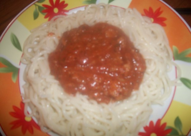 Fotografia przedstawiająca spaghetti carbonara ze świeżo tartym serem parmezan