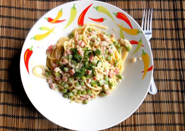 Fotografia przedstawiająca Spaghetti w lekkim sosie serowym ze speckiem i zielonym groszkiem